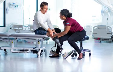 woman from a graduate physical therapy program assisting a patient