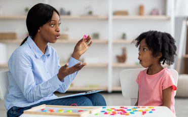 speech therapist working with little black girl