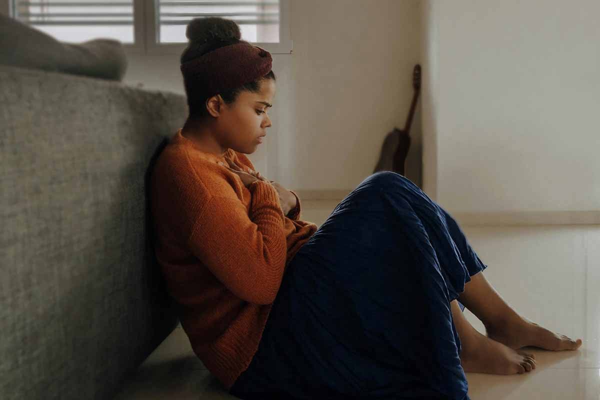 maternal depression, young mother sitting on the floor
