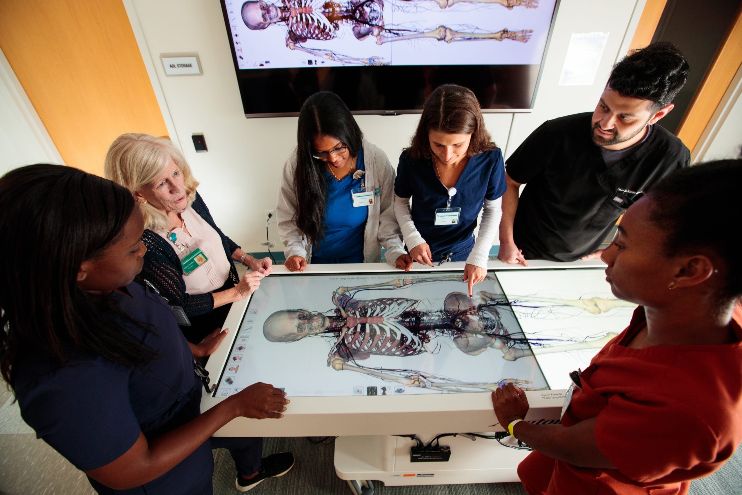 Students standing around anatomage table.